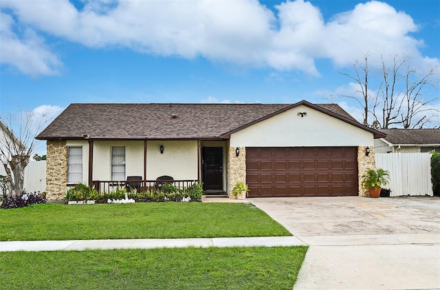 ranch-style home featuring a garage, a front yard, and covered porch