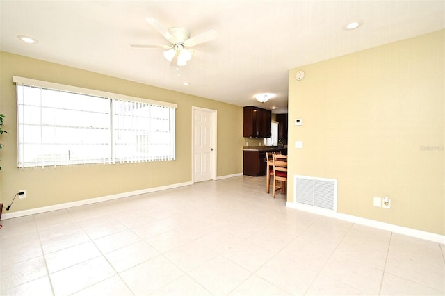 tiled spare room with ceiling fan