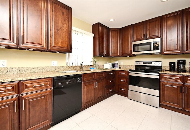 kitchen featuring light stone countertops, appliances with stainless steel finishes, sink, and light tile patterned floors