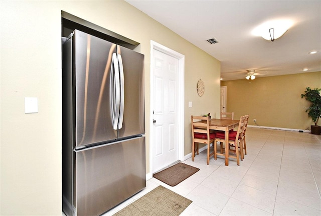 kitchen with light tile patterned flooring, stainless steel fridge, and ceiling fan