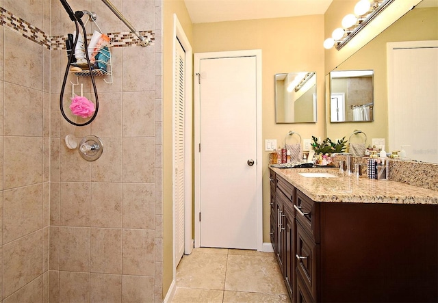 bathroom featuring vanity, tile patterned flooring, and a tile shower