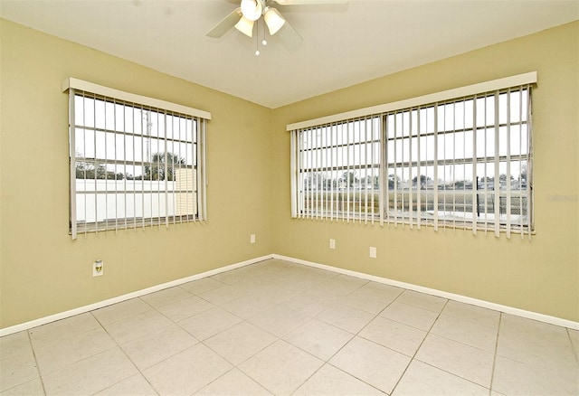 empty room with ceiling fan and tile patterned flooring