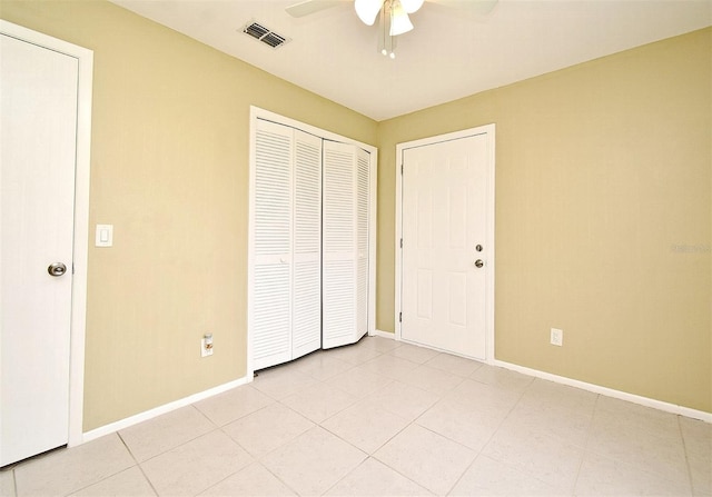 unfurnished bedroom featuring ceiling fan, a closet, and light tile patterned floors