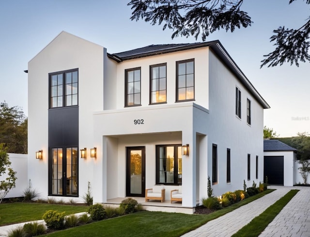 view of front of house featuring an outbuilding, a garage, and stucco siding