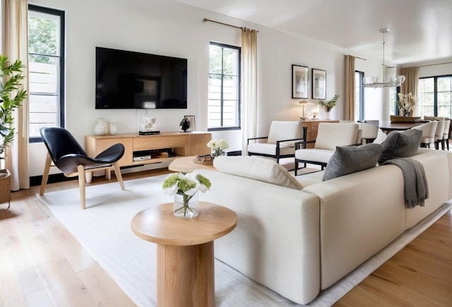 living area featuring light wood finished floors and a chandelier