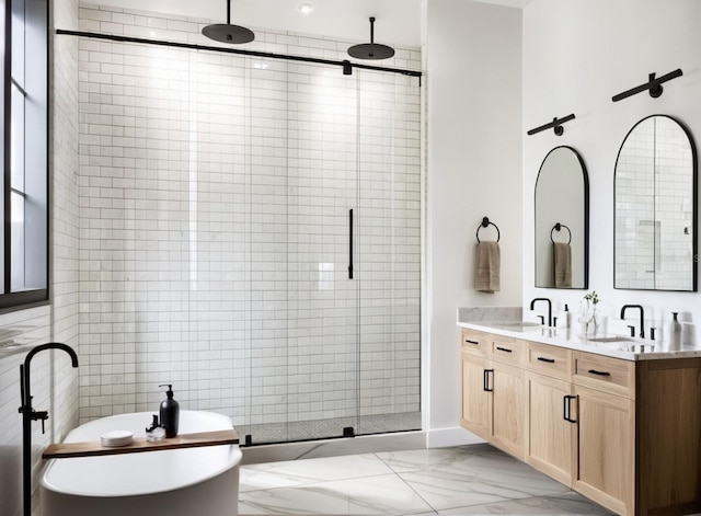 bathroom featuring a freestanding bath, double vanity, a stall shower, marble finish floor, and a sink