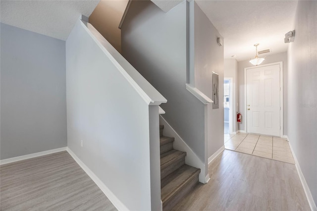 foyer entrance featuring light hardwood / wood-style floors and a textured ceiling