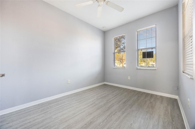 empty room with ceiling fan and light hardwood / wood-style flooring