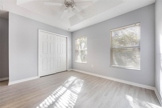 unfurnished bedroom with light hardwood / wood-style floors, a closet, and ceiling fan