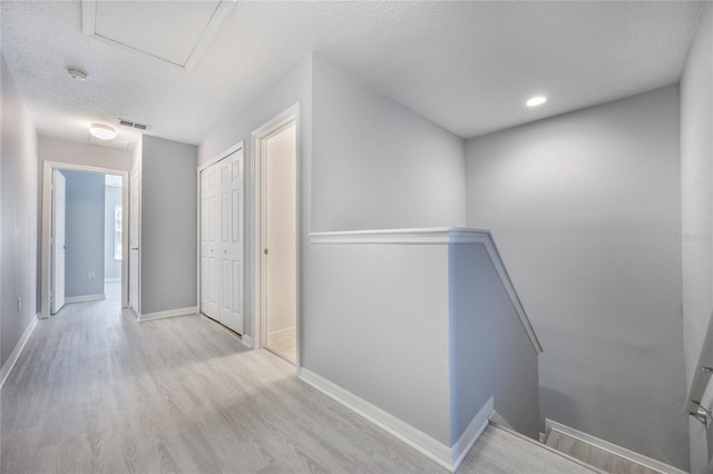 hallway featuring a textured ceiling and light wood-type flooring