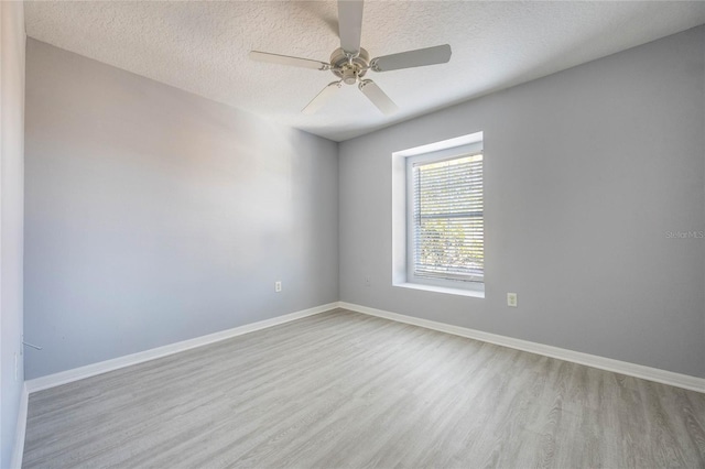 unfurnished room with ceiling fan, a textured ceiling, and light wood-type flooring