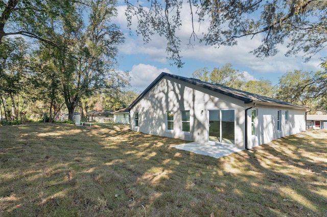 rear view of property featuring a patio and a yard