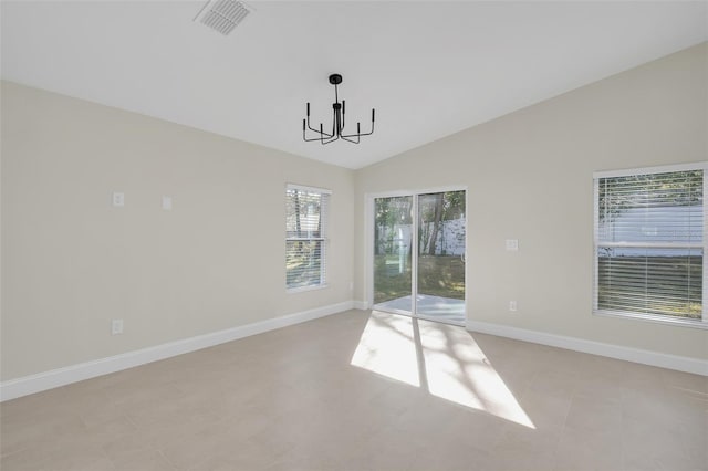 spare room with a chandelier and vaulted ceiling