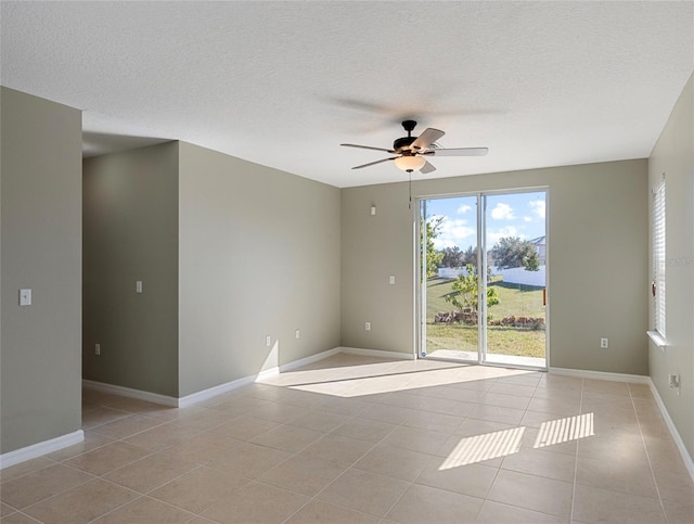 empty room with light tile patterned floors, a textured ceiling, and ceiling fan