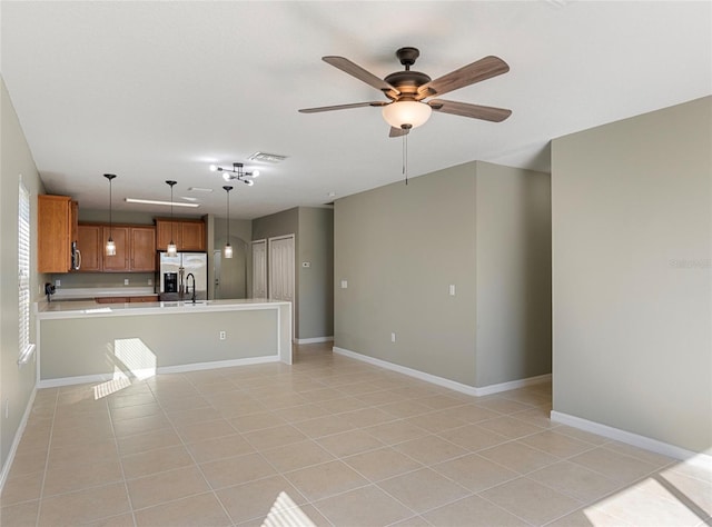 unfurnished living room featuring ceiling fan, sink, and light tile patterned floors