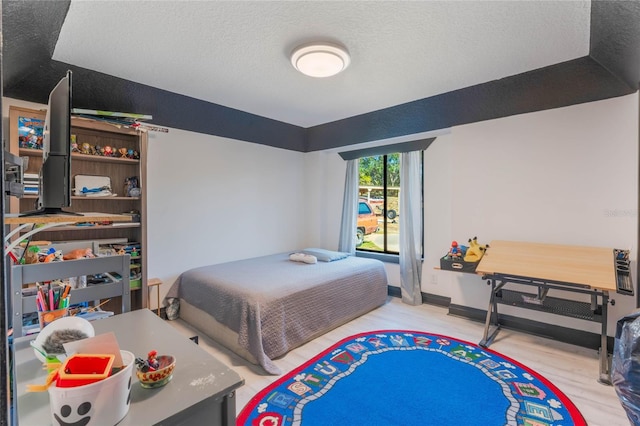 bedroom featuring a textured ceiling and light wood-type flooring