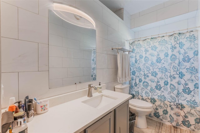 bathroom with a shower with curtain, vanity, toilet, and tile walls