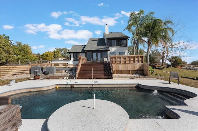 view of swimming pool featuring a wooden deck and a patio