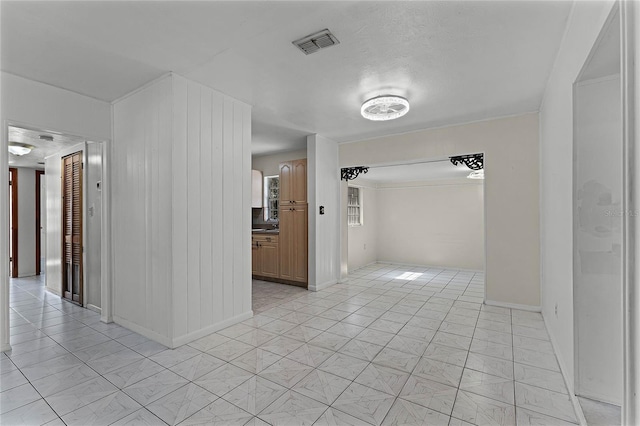 hall featuring a textured ceiling and light tile patterned floors