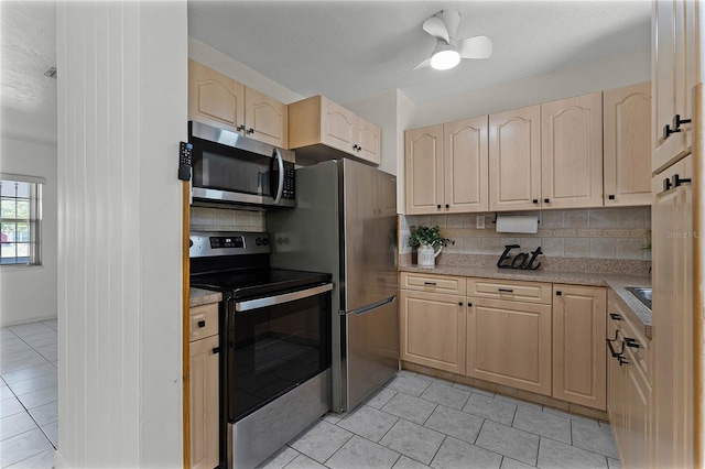 kitchen with appliances with stainless steel finishes, backsplash, and light brown cabinetry