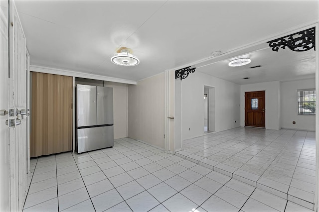 kitchen with light tile patterned floors and stainless steel refrigerator