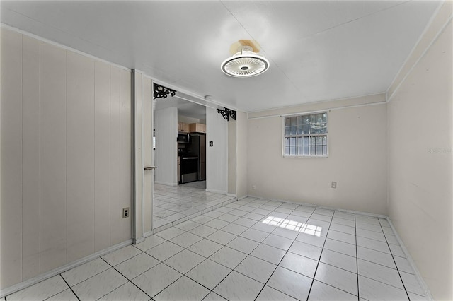 tiled spare room featuring wooden walls