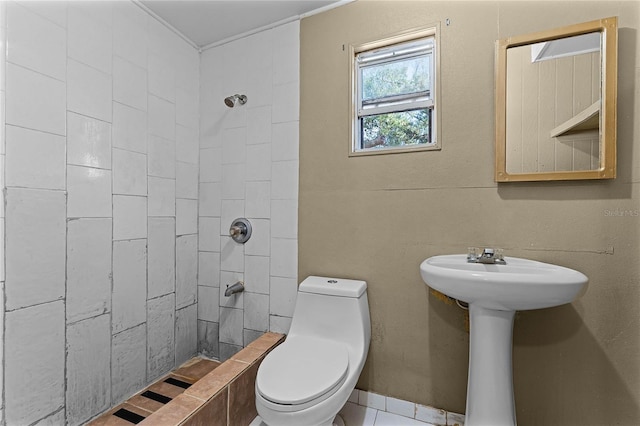 bathroom with a tile shower and toilet