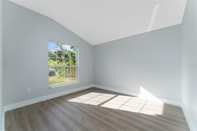 empty room featuring lofted ceiling and light hardwood / wood-style flooring