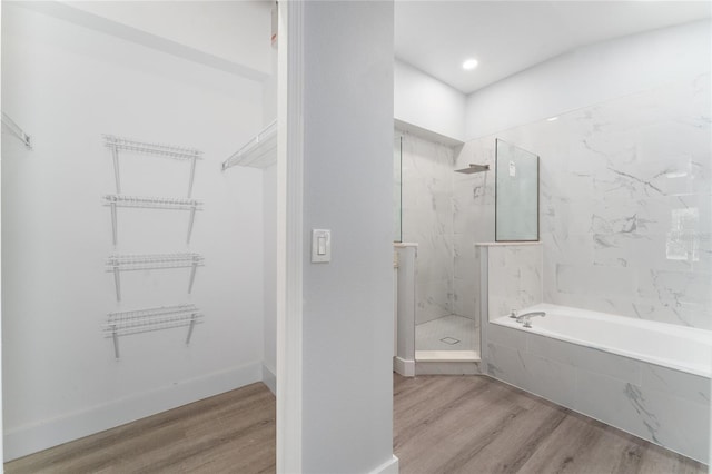 bathroom featuring shower with separate bathtub and hardwood / wood-style floors