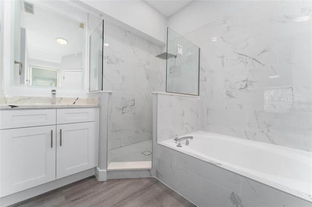 bathroom with hardwood / wood-style flooring, vanity, and separate shower and tub