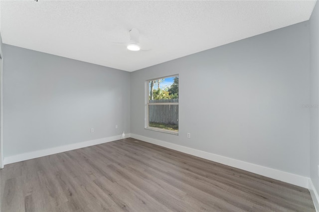 spare room with ceiling fan, a textured ceiling, and light hardwood / wood-style floors