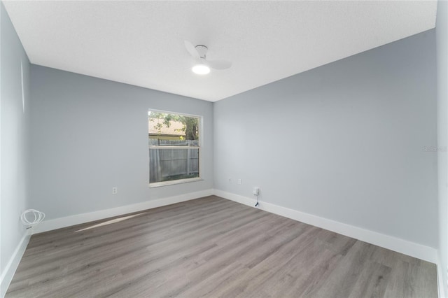 spare room with ceiling fan, light hardwood / wood-style flooring, and a textured ceiling