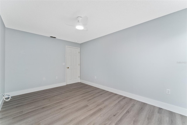 unfurnished room with ceiling fan, light hardwood / wood-style floors, and a textured ceiling