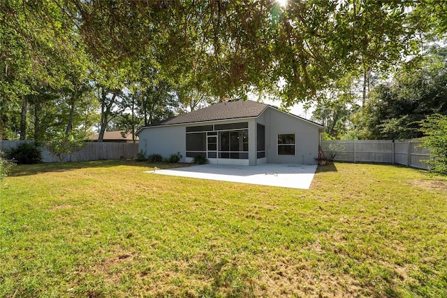 rear view of house with a patio area, a sunroom, and a lawn