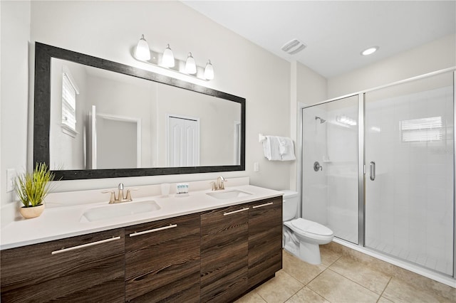 bathroom with tile patterned flooring, vanity, a shower with door, and toilet