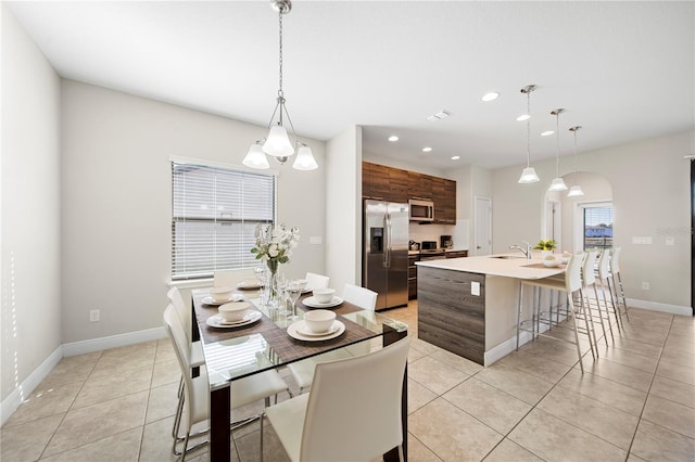 dining space featuring sink and light tile patterned floors