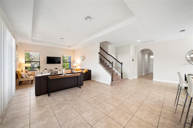 living room featuring light tile patterned flooring and a tray ceiling