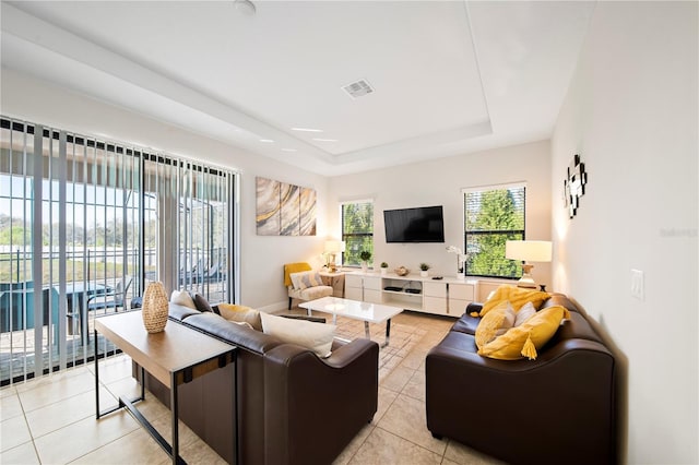 tiled living room featuring a raised ceiling