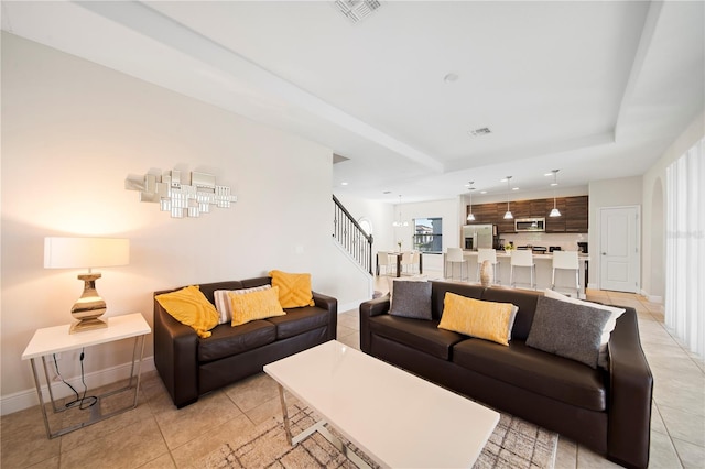 tiled living room featuring a raised ceiling