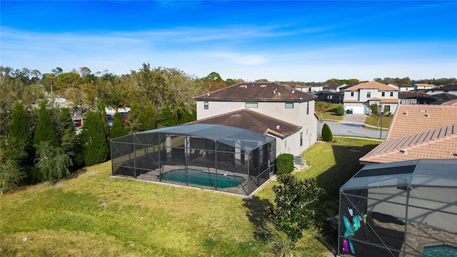 exterior space with a yard, a pool with hot tub, and glass enclosure