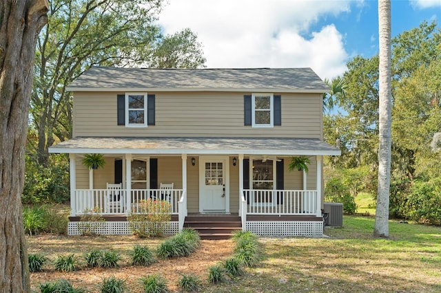 view of front of house with a porch, cooling unit, and a front yard