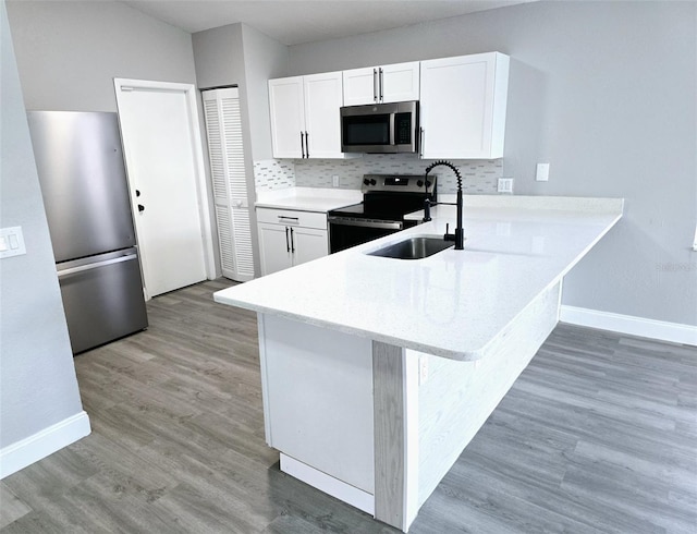 kitchen with white cabinetry, appliances with stainless steel finishes, sink, and backsplash