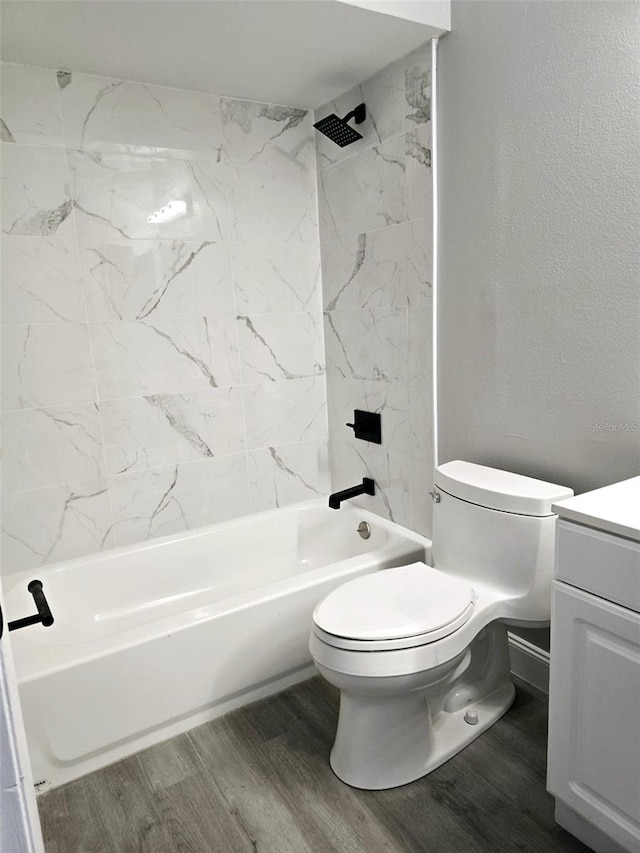 full bathroom with wood-type flooring, toilet, tiled shower / bath combo, and vanity