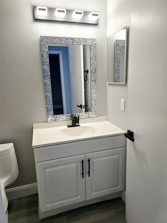 bathroom featuring vanity, toilet, and wood-type flooring