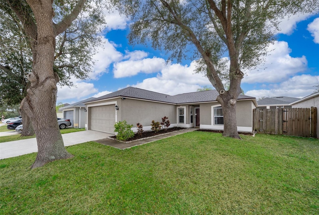 ranch-style house with a garage and a front lawn