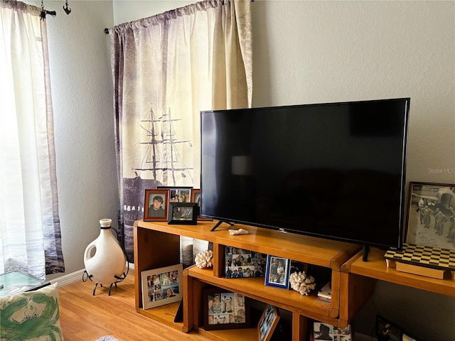 interior space featuring baseboards, wood finished floors, and a textured wall