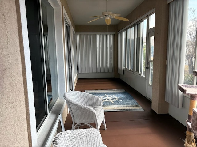 sunroom / solarium featuring a ceiling fan