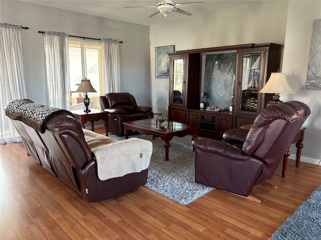 living area featuring ceiling fan, light wood-type flooring, and baseboards