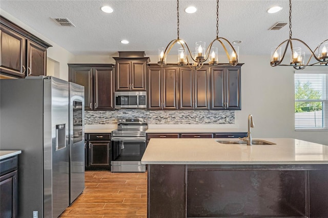 kitchen featuring a chandelier, visible vents, appliances with stainless steel finishes, and a sink