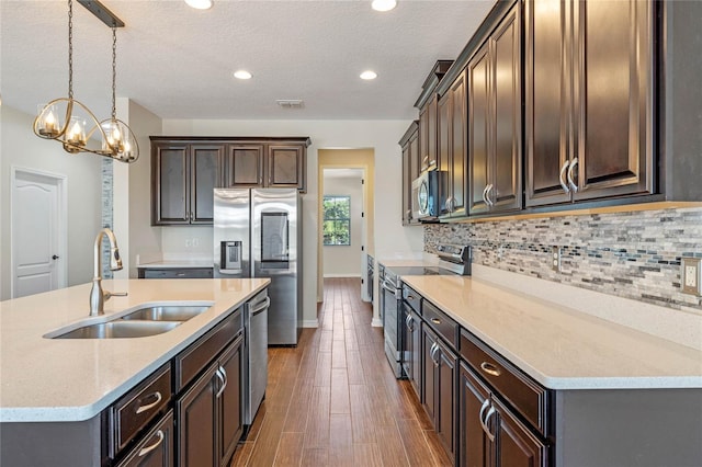 kitchen with a sink, decorative backsplash, visible vents, and stainless steel appliances